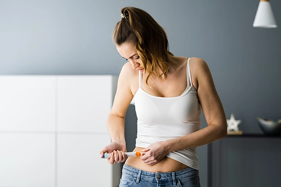 Person using Mounjaro injection pen on their abdomen.