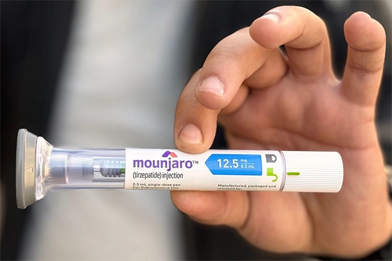 Hand holding Mounjaro injection pen labeled 12.5 mg.