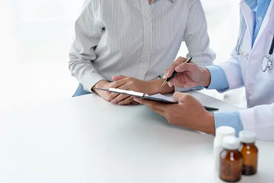 Doctor consulting with a patient and preparing medical records.