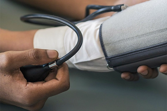 Close-up of a healthcare professional checking a patient's blood pressure with a sphygmomanometer.