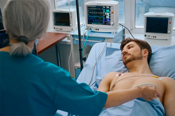 Patient undergoing a cardiac test in a hospital with a healthcare professional using diagnostic equipment.